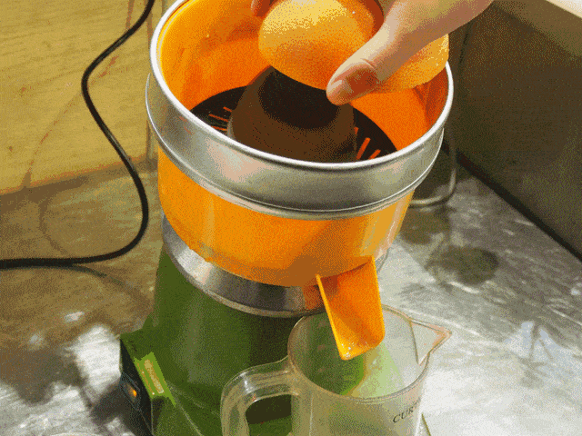 放到拱形的榨汁头上, 轻轻用手一压,十几秒, 榨出一杯新鲜的西柚汁