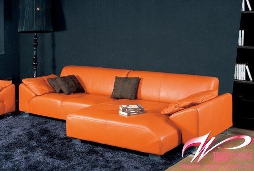 橘色的真皮沙发散发着细腻的光泽,沙发坐面分成不对称的两个部分