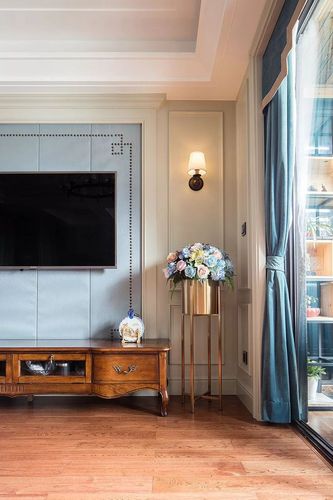 一张实木成品电视柜,侧边的边造型对壁灯,简单的电视墙透露着优雅端庄