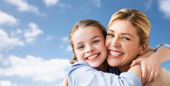 幸福的家庭关于女孩和母亲热烈地拥抱越过天照片
