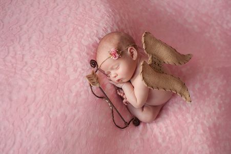 丘比特考拉刚出生的婴儿女孩戴着丘比特的翅膀照片