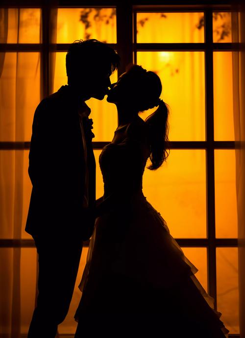 西式婚礼新郎新娘幸福亲吻的剪影浪漫氛围灯光