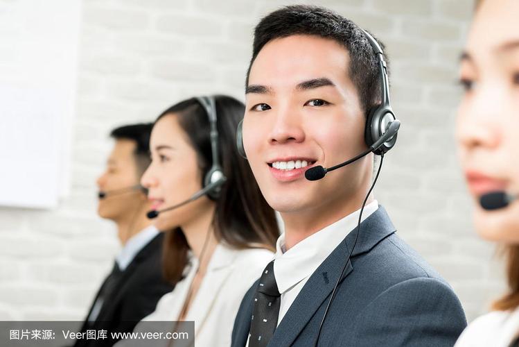 微笑的男性亚洲客户服务电话销售代理在呼叫中心
