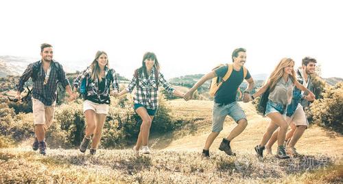 一群朋友在乡间草地上奔跑-快乐的友谊和自由的概念,年轻的千禧一代在