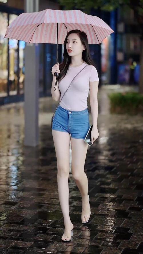 淡粉色的t恤搭配牛仔短裤超显美女的大长腿展现出了独特的美