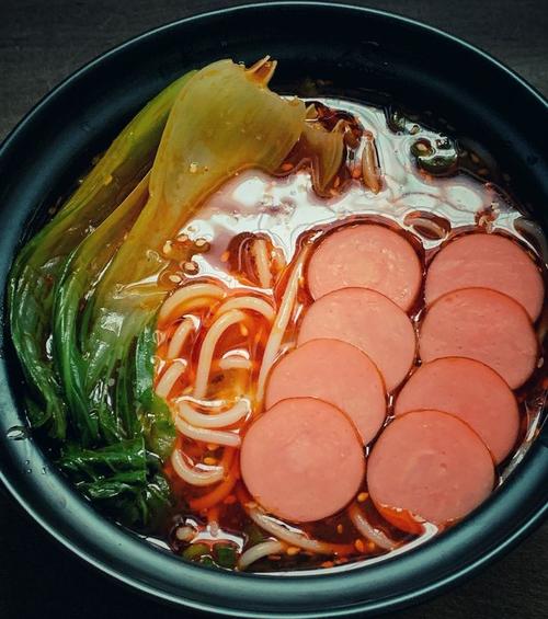 香辣米线的做法,香辣米线的用料,放入之前煮过的青菜叶和切好的火腿肠