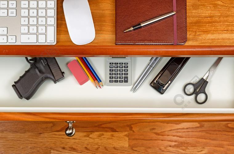 开放式办公桌抽屉的高角度拍摄里面有隐藏的个人武器樱桃木桌面有电脑