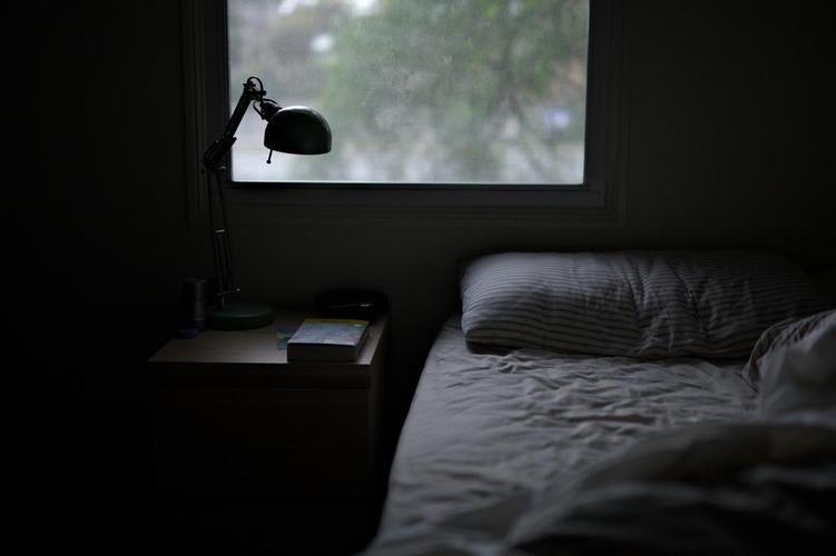 阴暗的卧室床和台灯背景图片