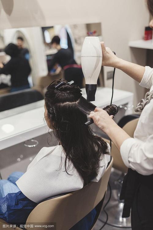 女发型师在发廊为年轻女性做发型