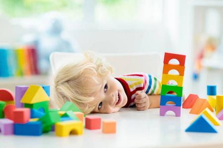 小男孩建造积木玩具塔. 为幼儿提供教育和创造性的玩具和游戏.