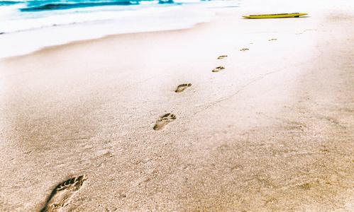 的沙子的人类脚印火烈鸟在海滩上孩子的脚印在沙滩上的沙子腿在沙滩上