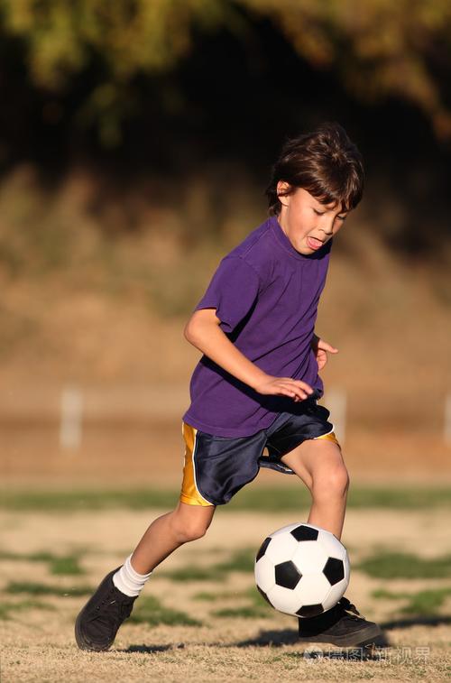 在下午的光线中踢足球的男孩照片-正版商用图片19xxst-摄图新视界