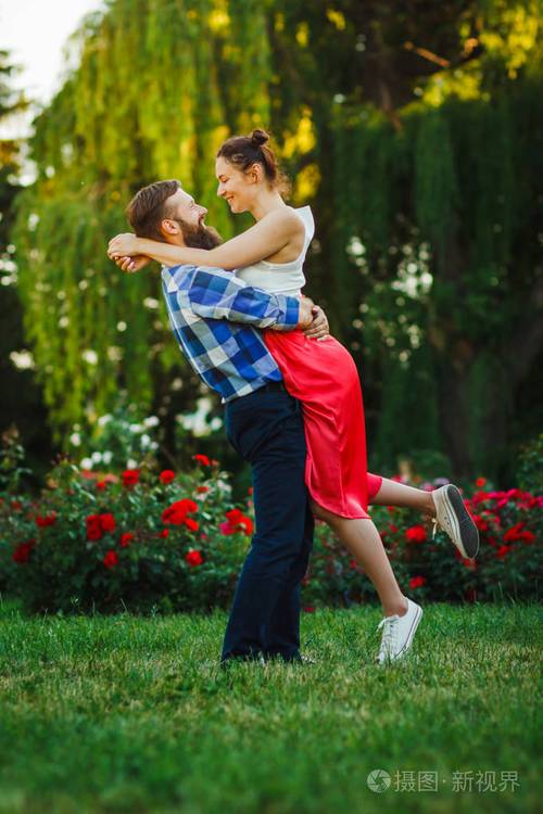 幸福的年轻夫妇相爱拥抱享受春日爱的男人牵着他的女人在公园里无忧无