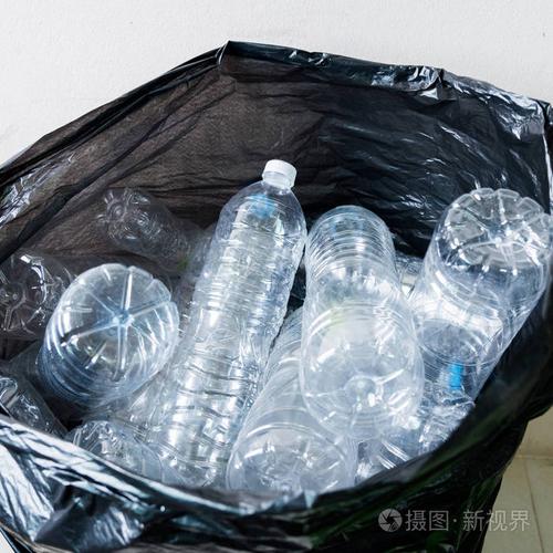 在黑色的垃圾袋里等待被采取回收塑料瓶