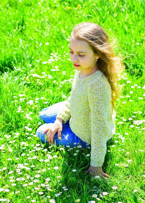 女孩坐在草地上的草地, 绿色的背景.