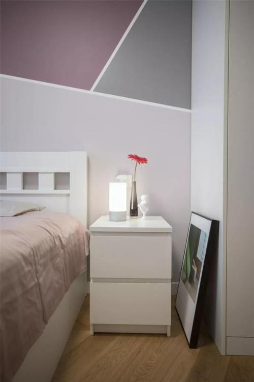卧室的床头墙以美纹纸做了个拼色墙面,搭配淡粉色的床单,呈现出姻个