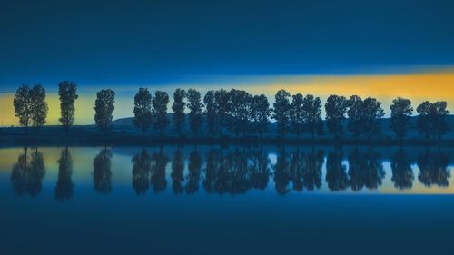 树木倒映在湖蓝色高清桌面壁纸:宽屏:高清晰度:全屏