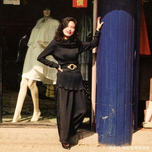 一个卖时装的服装店门前,打扮时髦,颜值超高的女老板正站在她的店门口