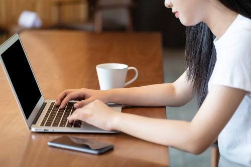 女生咖啡馆使用电脑打字特写