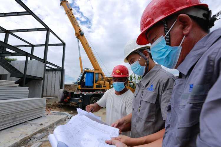 在项目工地,唐山市易新建筑科技有限责任公司的工人进行板材安装施工.