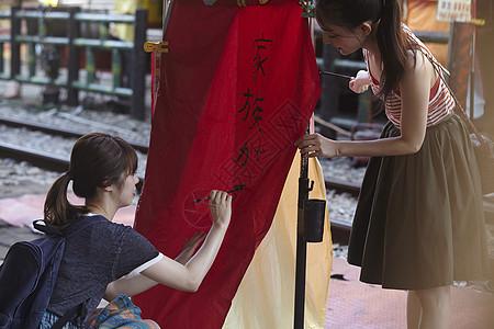 两个女游客在祈福灯笼上写字台湾图片素材