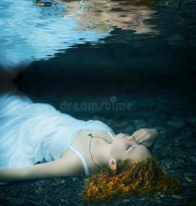 在水下游泳的女人妇女在池水下年轻美女穿着蓝色的衣服躺在河里淹死大