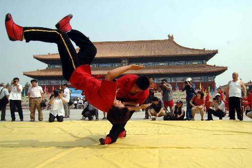 6月9日,老北京跤艺队成员在北京太庙前在表演摔跤.