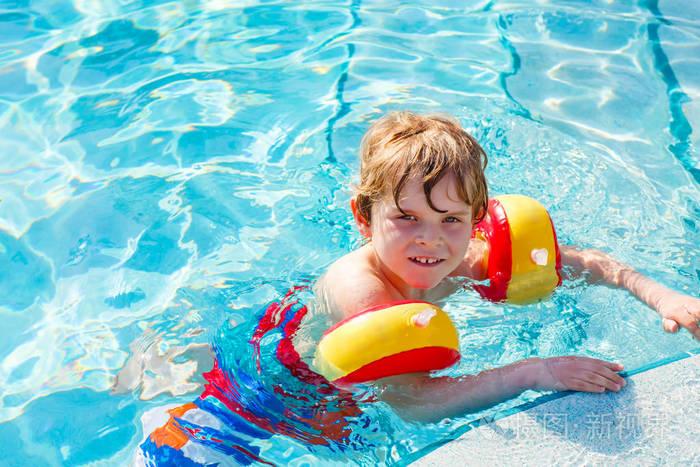 快乐的小小孩男孩在游泳池里玩.积极的快乐的孩子,学习游泳.