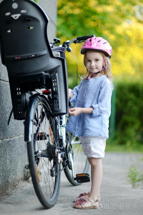 小女孩准备骑一辆自行车