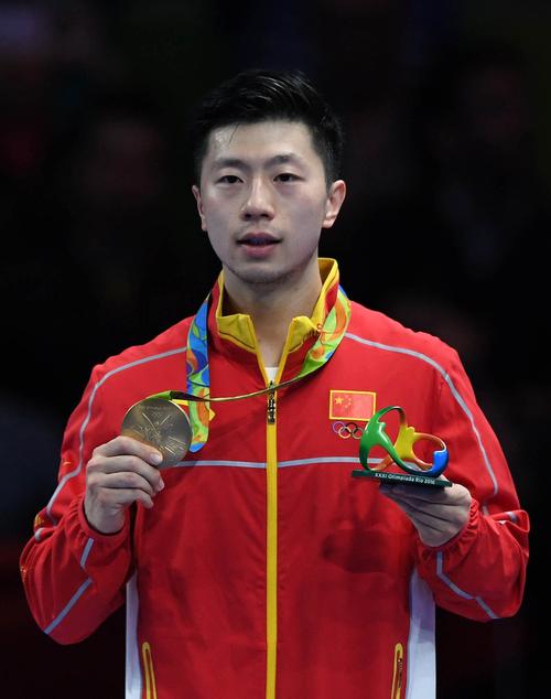 2016年里约奥运会乒乓球男单决赛中,中国选手马龙在领奖台上展示金牌