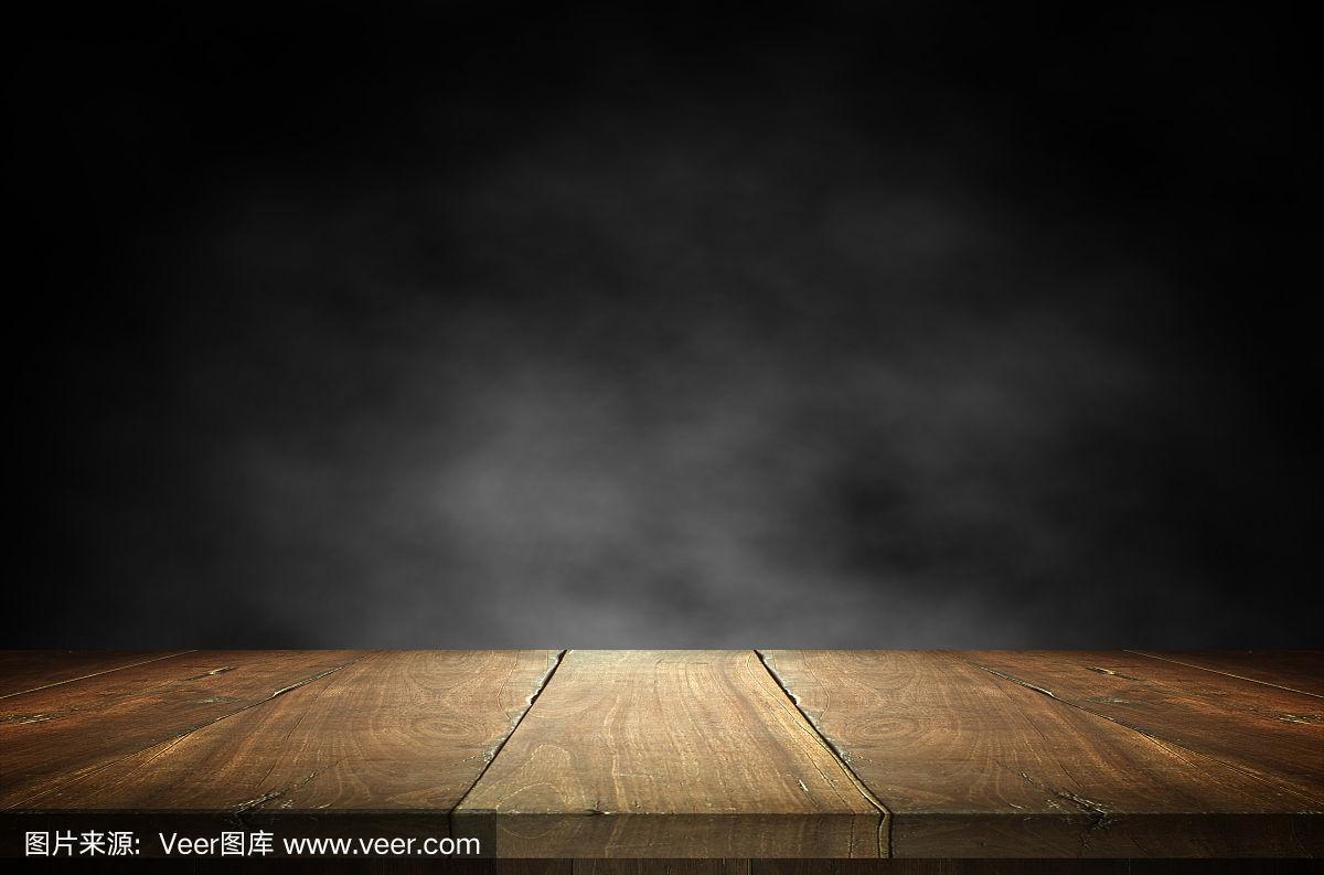旧的木质桌面,在黑暗的背景中有烟雾.