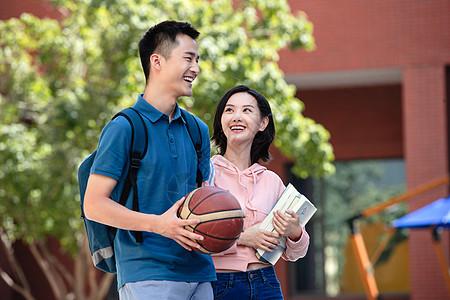 篮球 阳光学生背着大学生情侣在校园里背景