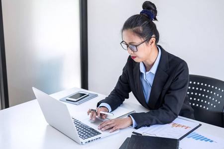 智能女性女实业家在笔记本电脑上工作分析业务战略和销售业绩合同在
