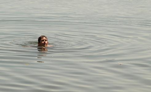 小男孩在河中游泳照片