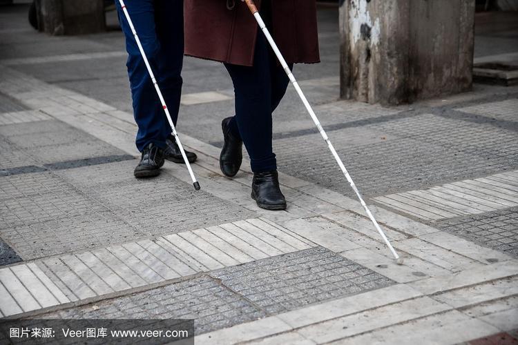 盲人用白色拐杖在街上行走