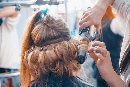 理发师对一个年轻女孩做头发延伸照片