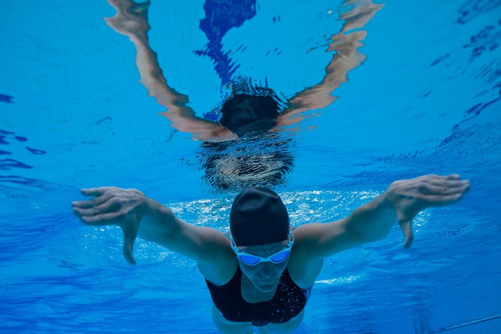 水下游泳,女游泳运动员在泳池水下潜水