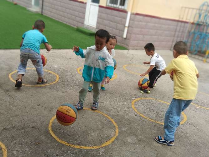 休育游戏《花样拍球》大班的幼儿练习连续单手,双手交替拍球或行进间