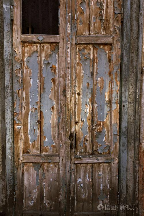 贫穷小区的旧木门. 古老的老式木头在一堵旧墙上.