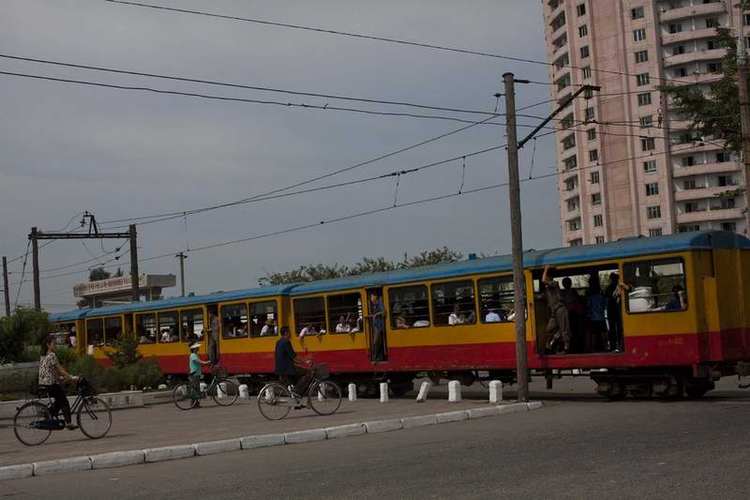 当地时间2012年8月11日,朝鲜咸兴,一辆火车穿过城市.