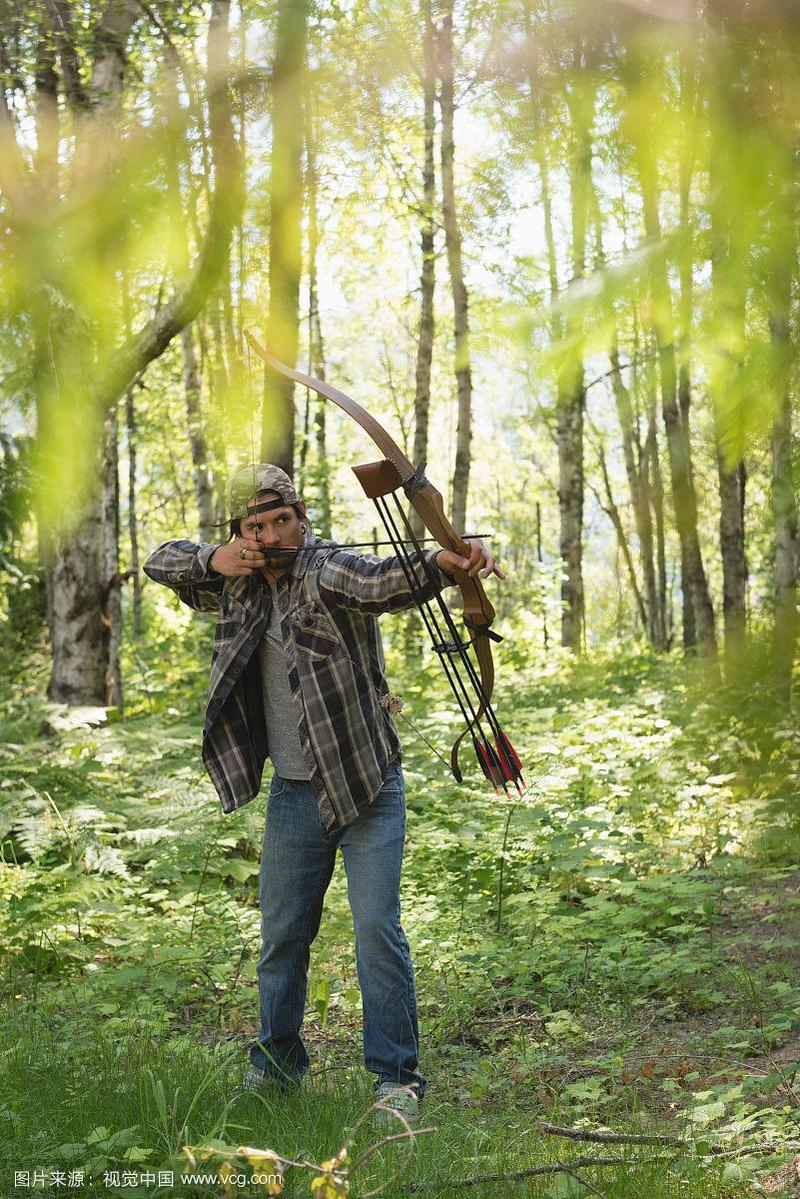 在森林中用弓和箭瞄准的射箭