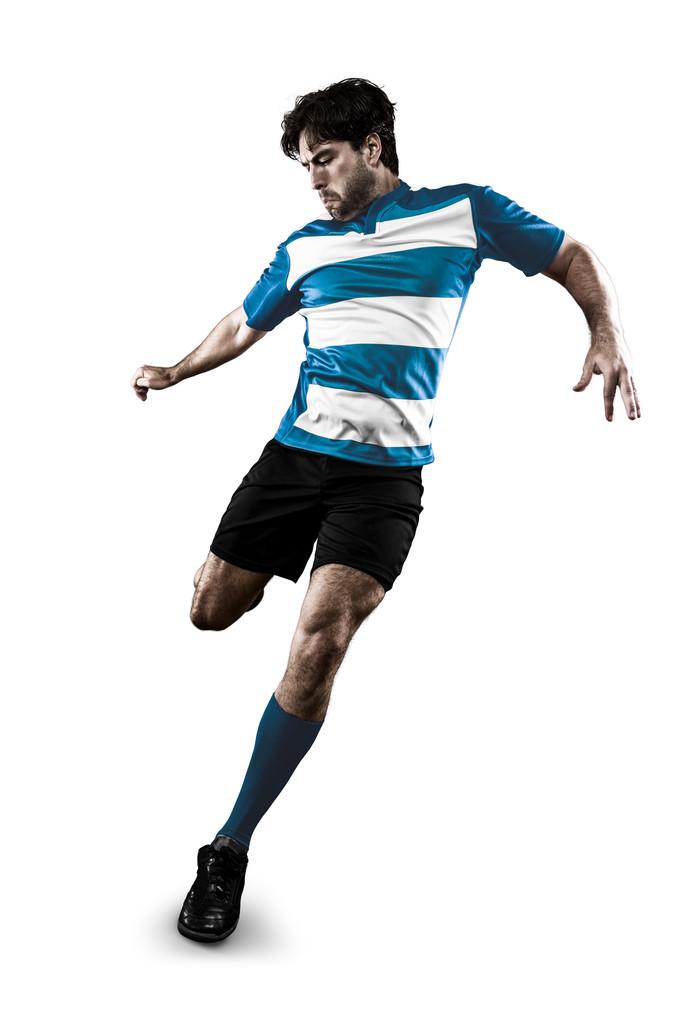 橄榄球球员,在蓝色的制服踢橄榄球运动员.白色背景