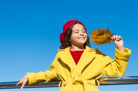 秋天温暖季节愉快的时刻.男孩女孩微笑的脸保持叶子背景的天空.