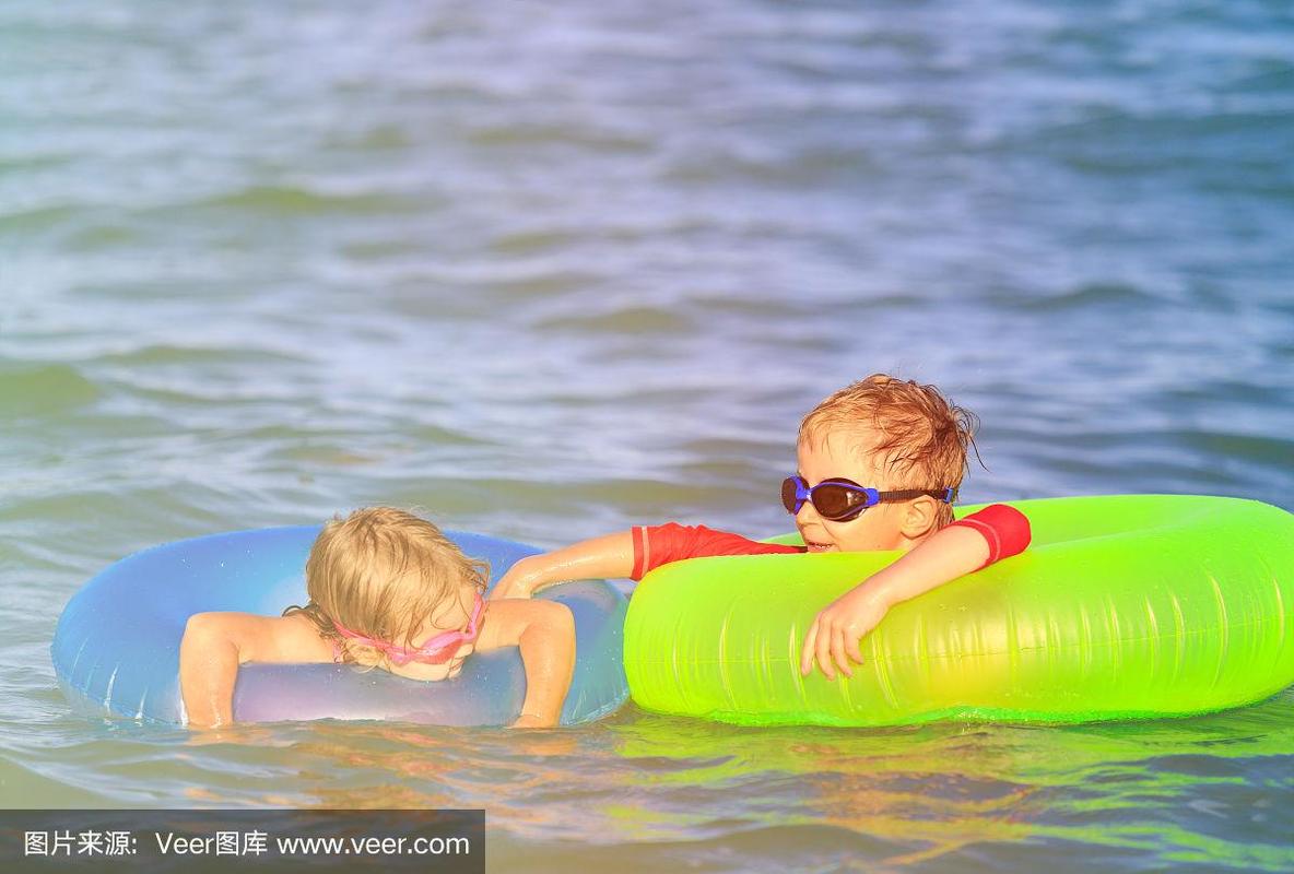 快乐的小男孩和小女孩在夏天的海滩游泳