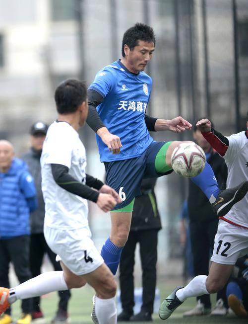 4月1日,白纸坊樱桃园队球员邵佳一(右)在比赛中停球.