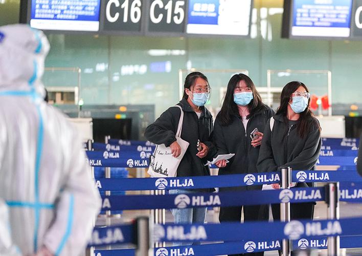 10月8日,在哈尔滨太平国际机场,旅客准备进入安检通道.