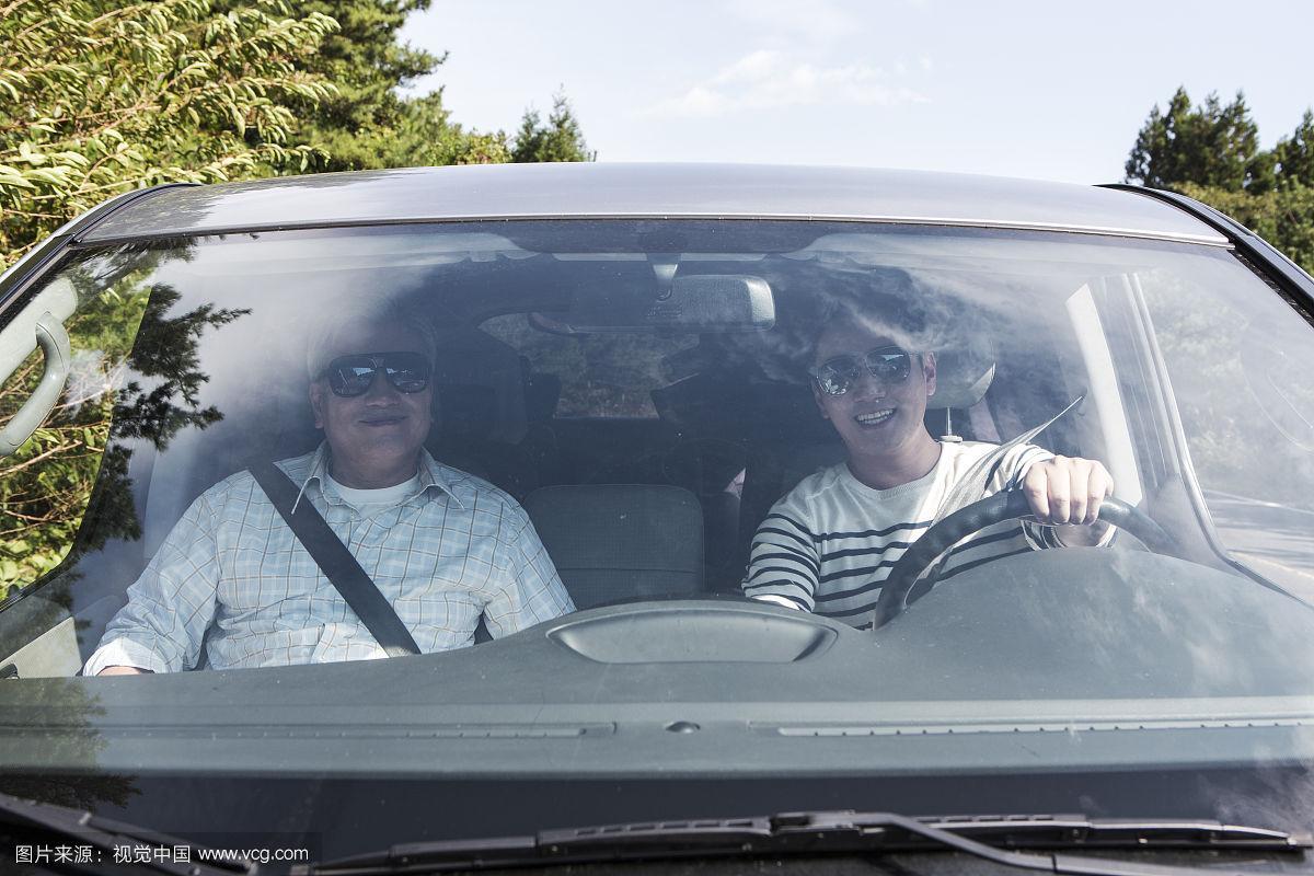 两个男人戴着墨镜开车的照片