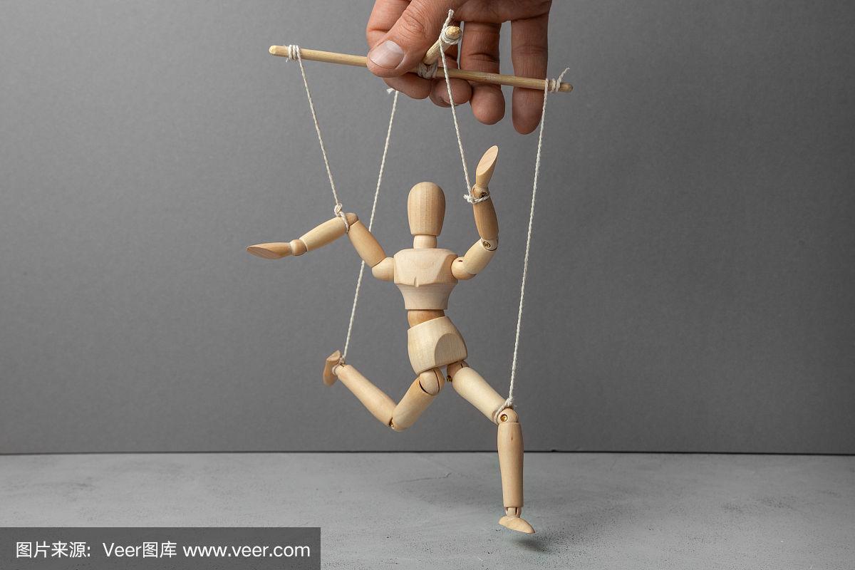 木偶师用绳子拉着娃娃.玩偶不服从操纵木偶的人.