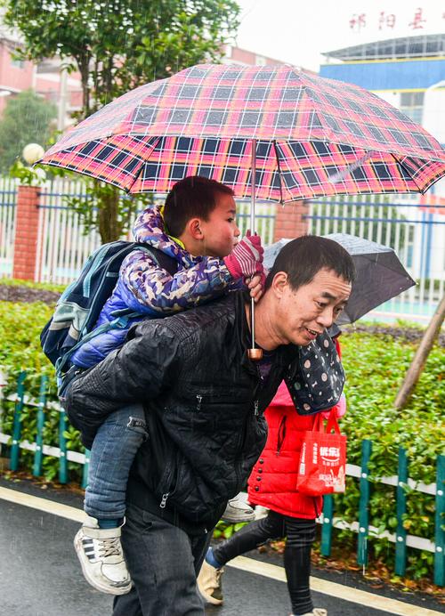 2019年1月11日拍于祁阳县明德小学,爸爸背着儿子回家.