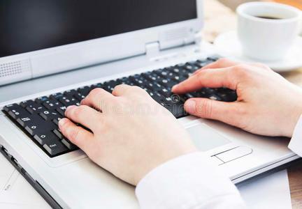 双手在办公室的电脑键盘上打字照片